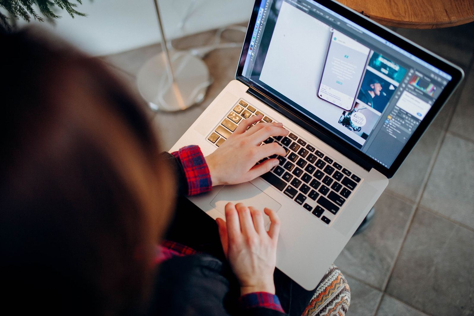 A freelance designer working on a laptop at a home office desk