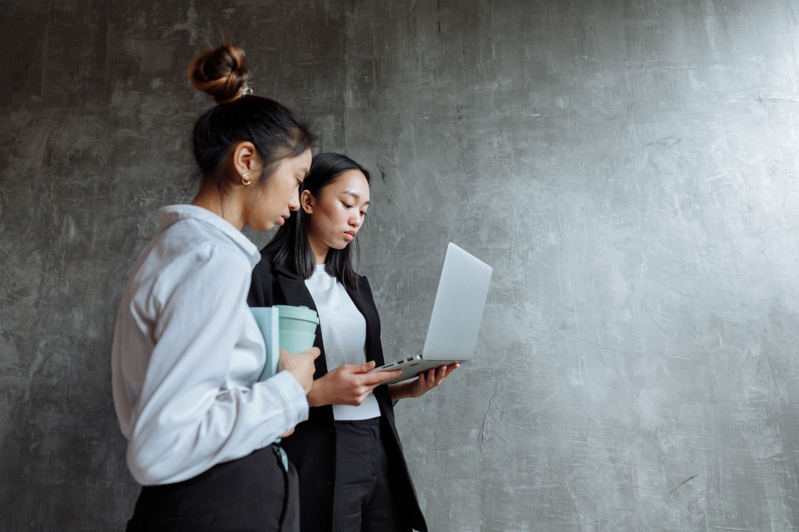 Two colleagues discussing content together at a laptop