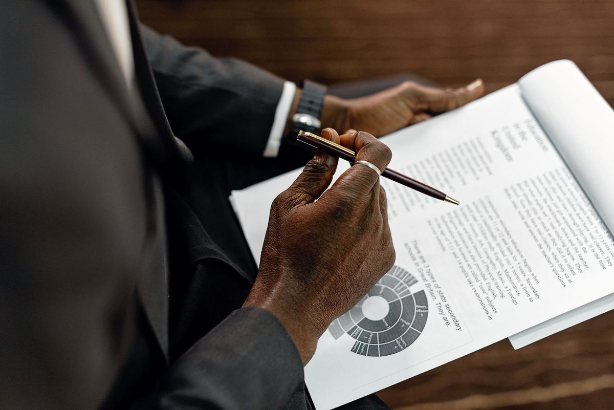 A person reviewing a printed document and taking notes