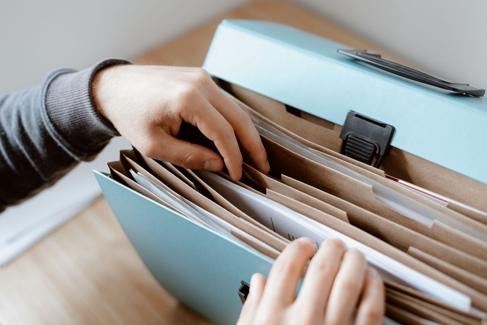 Hands sorting through document files on a desk