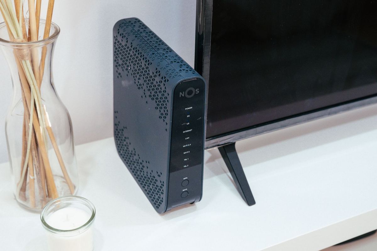 A home Wi-Fi router standing on a shelf next to a television