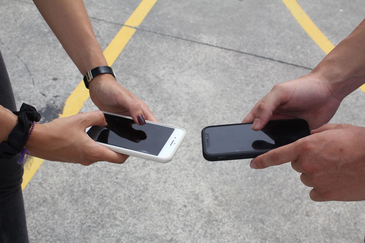 Two people holding phones close together to share a file