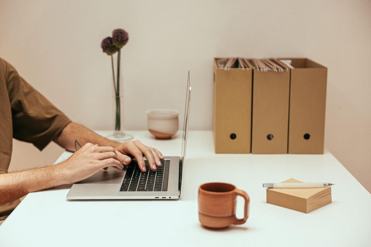 A person using a laptop to upload a file in an office