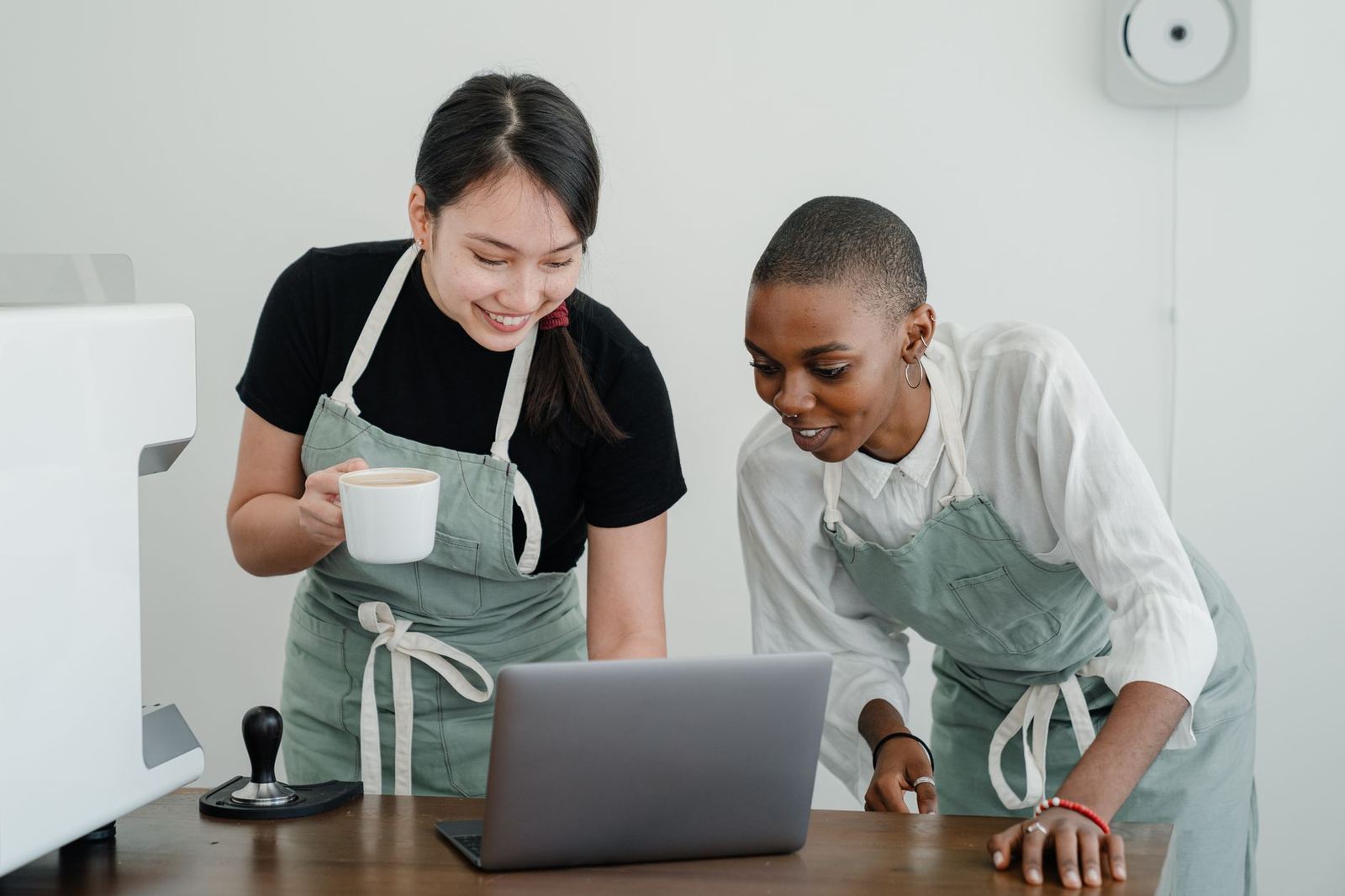 Two colleagues discussing something on a laptop screen