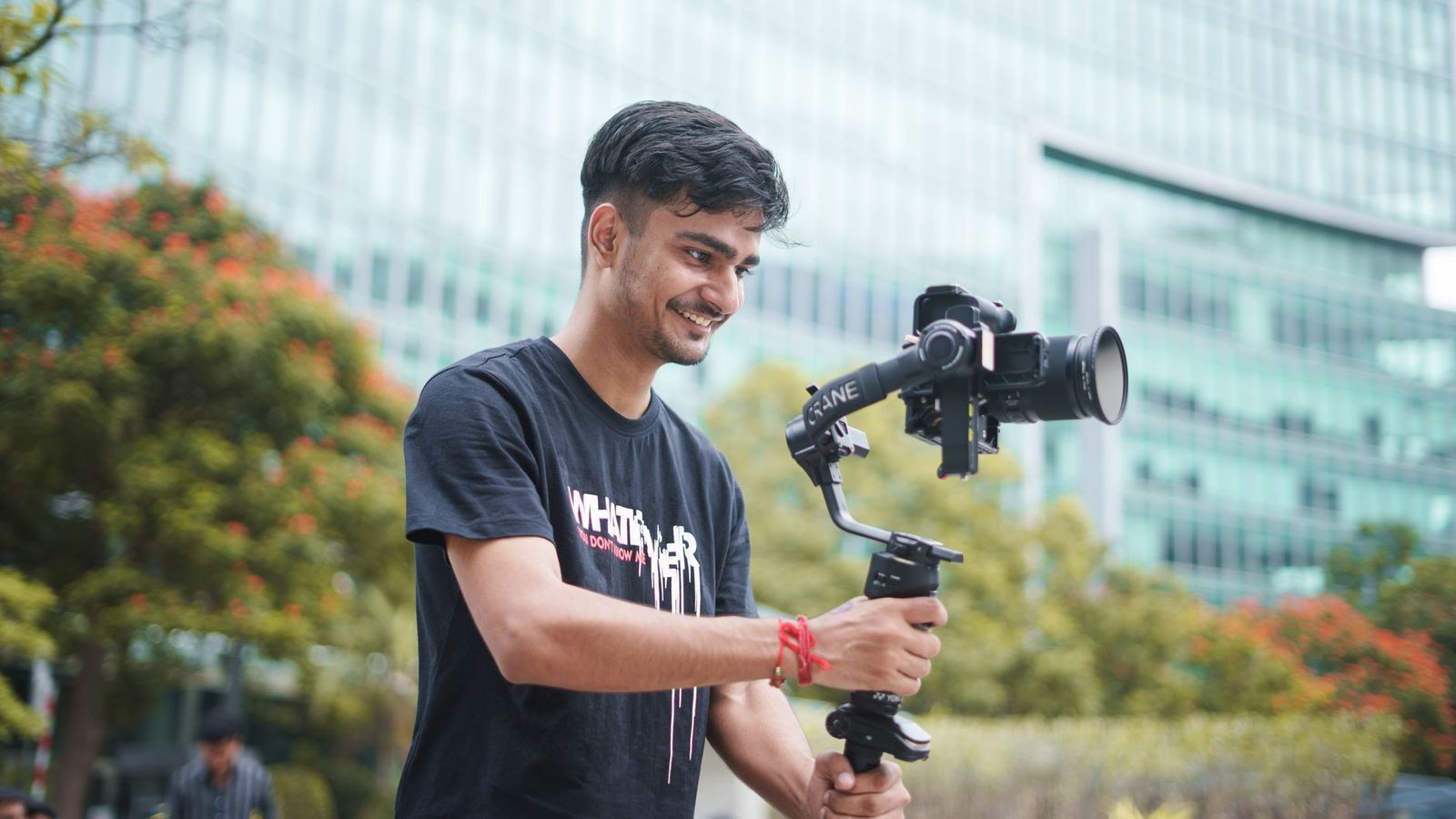 A creator filming video content on a camera stabilizer rig outdoors