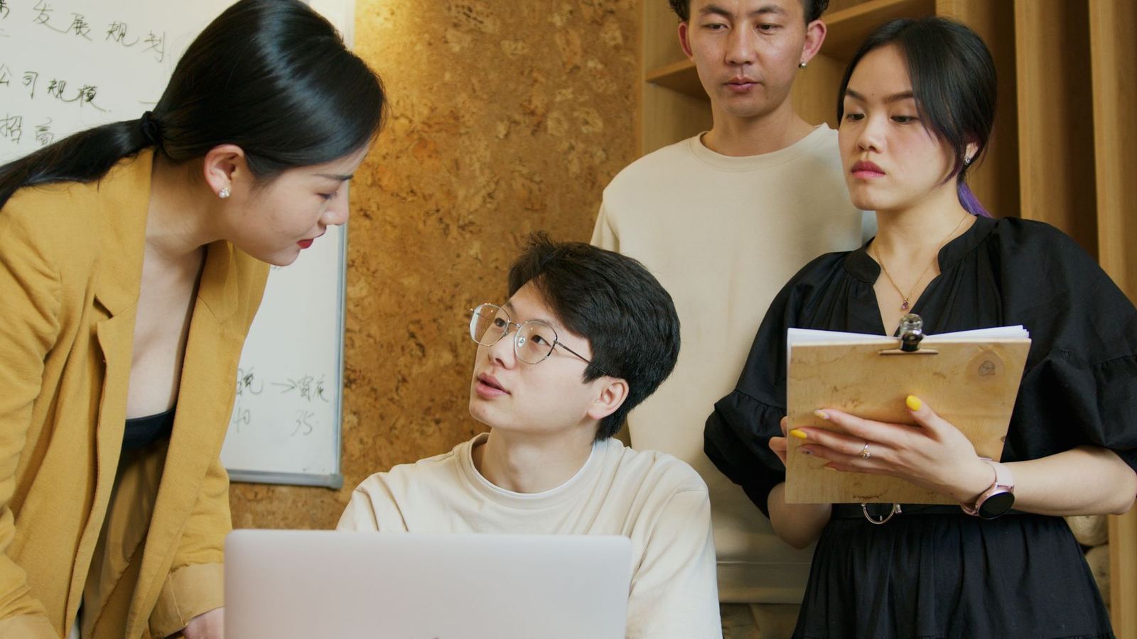 A small team reviewing feedback together around a laptop